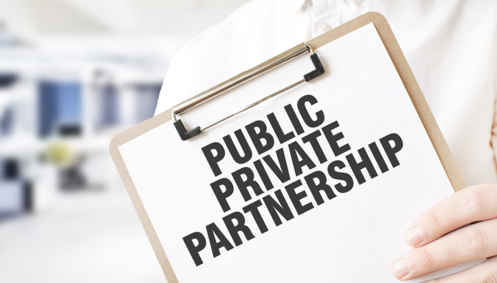 Text PUBLIC PRIVATE PARTNERSHIP on white paper plate in businessman hands in office. Business concept